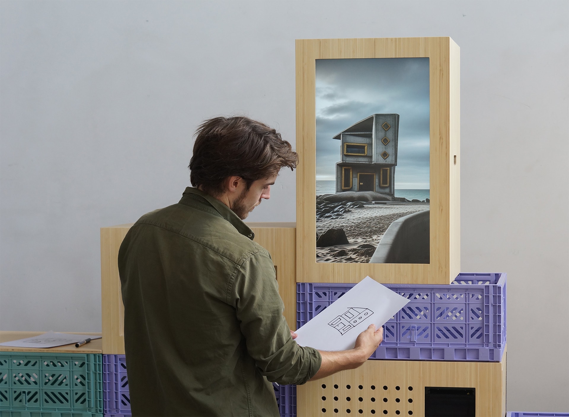 Man holding drawing in front of interactive installation